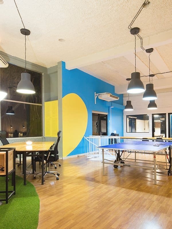 Bright indoor game area with ping pong table and colorful wall decor.